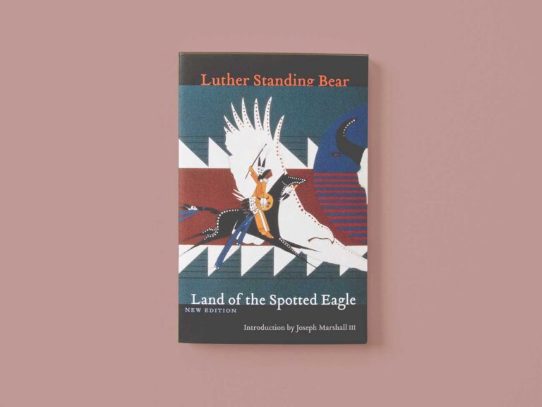 The book, Land of the Spotted Eagle, centered on a red-ish background.